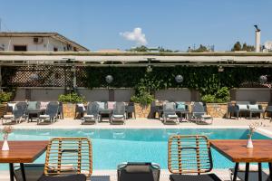 a patio with tables and chairs next to a pool at Telesilla Hotel in Kontokali