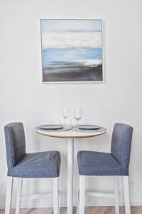 瓦朗西納的住宿－* Lasuite #1 BLUE *，一张桌子、两把椅子和墙上的一幅画