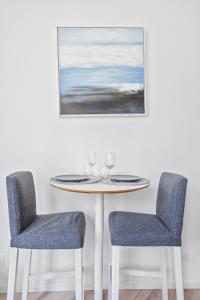 uma mesa com duas cadeiras e um quadro na parede em * Lasuite #1 BLUE * em Valenciennes