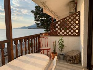 a balcony with a table and a chair and the ocean at A Place of Philoxenia in Aíyira