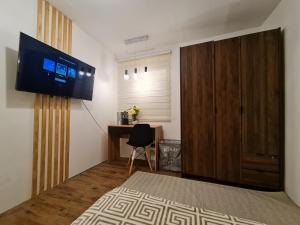 ein Schlafzimmer mit Fernseher und Schreibtisch mit Stuhl in der Unterkunft MC RESIDENCES in General Santos