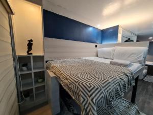 ein kleines Schlafzimmer mit einem Bett und einer blauen Wand in der Unterkunft MC RESIDENCES in General Santos