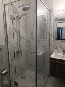 a bathroom with a shower and a sink at Apartament Kali in Ahtopol
