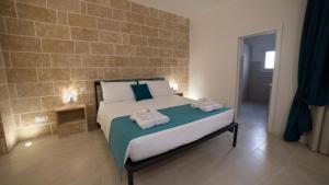 ein Schlafzimmer mit einem Bett mit Handtüchern darauf in der Unterkunft Corte Sant'Oronzo in Diso