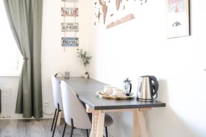mesa de comedor con sillas blancas y mesa negra en Studio apartment in the heart of Jakobstad, en Jakobstad