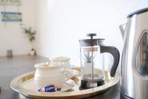 a tray with a coffee maker and cups on a counter at Studio apartment in the heart of Jakobstad in Pietarsaari