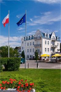 duas bandeiras estão a voar em frente a um edifício em Hotel Nautilus em Międzyzdroje