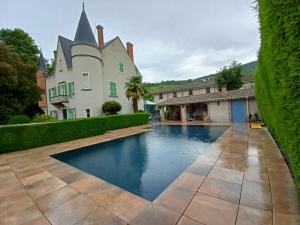 a swimming pool in front of a house at Au Fond de la Cour in Veyre-Monton