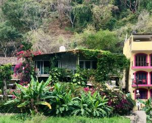 dom z kwiatami i roślinami przed nim w obiekcie Casa Cereza Apartments w mieście Puerto Vallarta