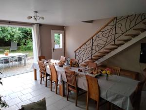 uma sala de jantar com uma mesa e uma escada em Au Saint-Amand em Poissons