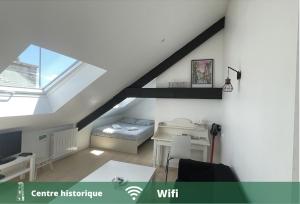 a attic room with a bed and a desk at Cοcοοn in Dinan