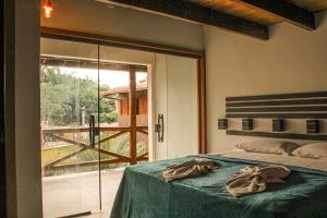 a bedroom with a bed and a sliding glass door at Pousada Recanto da Concha in Itacaré