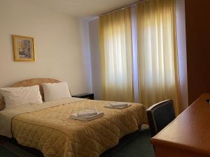 ein Hotelzimmer mit einem Bett, auf dem zwei Handtücher liegen in der Unterkunft Vila Luka in Ohrid