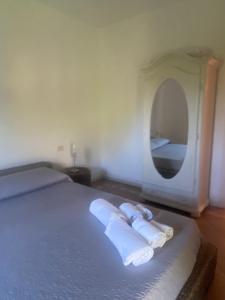 リーシャ・ディ・ヴァッカにあるResidence Gli Oleandri 114のベッドルーム1室(ベッド1台、ロールタオル2枚、鏡付)