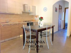 a kitchen with a dining room table and chairs at Villetta Sapphire con piscina in Costa Paradiso