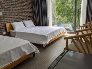 a bedroom with two beds and a large window at ᴛᴀᴍ ᴄᴏᴄ ᴄᴏᴄᴏᴏɴ ʜᴏᴍᴇsᴛᴀʏ in Ninh Binh +75 photos