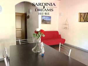 a living room with a table and a red couch at Villetta Sapphire con piscina in Costa Paradiso