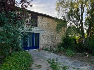 een stenen huis met een blauwe deur en een tuin bij Les 3 pigeons in Bressuire