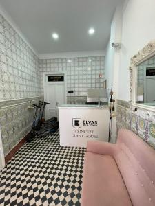 Habitación con cama rosa y barra. en Concept Guest House en Elvas