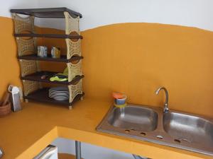 a kitchen counter with a sink and a shelf at Boca Brava Lodge in Boca Chica