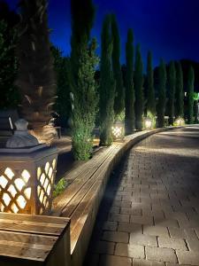 a row of trees and a park bench at night at La tanière de Bonneville in Bonneville-sur-Touques