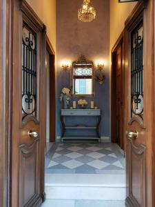 a hallway with two doors and a sink and a mirror at Arion Syros in Ermoupoli