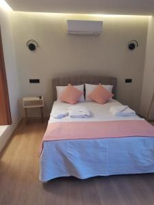 a bedroom with a bed with pink and blue sheets at SIĞACIK SEN KONUK EVİ in Seferihisar