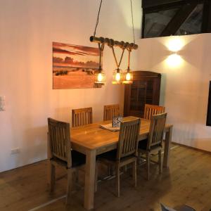 una sala da pranzo con tavolo e sedie in legno di Gut Strackholt FeWo Seemannsgarn a Großefehn 