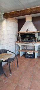 a table and a chair next to a pizza oven at CASA JARDIN in Vilagarcia de Arousa