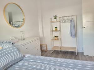 a bedroom with a bed and a mirror and a dresser at Apartamento en Rota con piscina y parking junto al mar in Rota