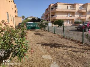 ein Zaun vor einem Gebäude mit einigen Pflanzen in der Unterkunft Les jardins d'armand in Valras-Plage