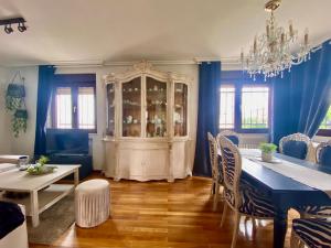 a dining room with a table and a china cabinet at Housing León Casa con Jardín in León