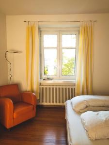 een slaapkamer met een bed, een stoel en een raam bij Bolzano with a view in Bolzano