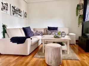 un soggiorno con divano bianco e tavolo di Housing León Casa con Jardín a León