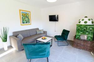 ein Wohnzimmer mit einem Sofa, einem Tisch und Stühlen in der Unterkunft Seeappartements Christiane Haus 97 in Krumpendorf am Wörthersee