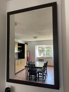 a dining room mirror with a table and chairs at APARTMA VATOVEC in Ankaran