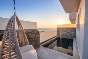 a house with a swing and a swimming pool at Thalasidi Luxury Suites in Karpathos Town
