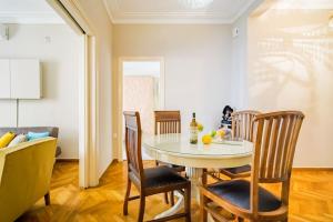 comedor con mesa y sillas en Emporikon Apartment Steps From Historic Center, en Atenas