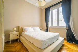 Un dormitorio con una cama grande y una ventana en Emporikon Apartment Steps From Historic Center, en Atenas