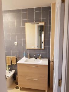 a bathroom with a sink and a mirror and a toilet at Unamuno in Puerto del Rosario