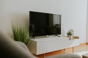 TV de pantalla plana grande en un centro de entretenimiento blanco en Apartamento REY ENEO, en Haro