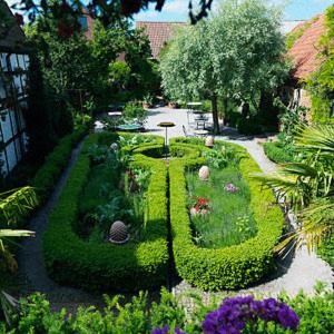 a garden with a circular hedge in the middle at Gårdens B&B in Simrishamn