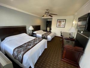 a hotel room with two beds and a flat screen tv at Hollywood Guest Inn in Los Angeles