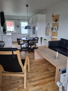 uma cozinha e sala de estar com mesa e cadeiras em Løkken centrum ferielejlighed-apartment 4E em Lokken