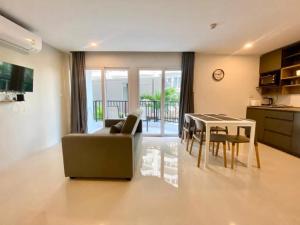 クレンにあるMantra Beach Condominimum, 2 bedrooms, Laem Mae Phim Beachのソファとテーブルのあるリビングルーム