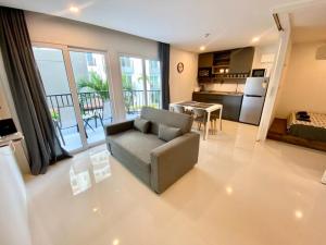 a large living room with a couch and a kitchen at Mantra Beach Condominimum, 2 bedrooms, Laem Mae Phim Beach in Klaeng