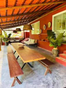sala de estar con mesa de madera y bancos en Grand Casa Rossa, en Morro de São Paulo
