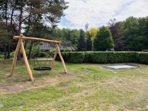 a swing set in a yard with at Glamping lodge with Eco-Wellness in Zeewolde