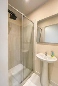 een badkamer met een glazen douche en een wastafel bij The Luun Hostel in Bogota