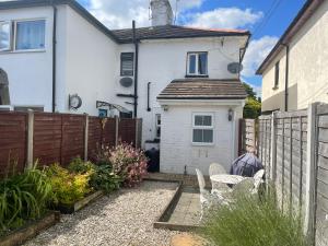a backyard with a fence and a white house at April Cottage Ringwood in Ringwood +3 photos